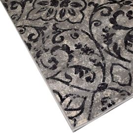Natco Milan "Hollis" Contemporary Area Rug: A contemporary Hollis area rug by Natco Milan. It features a scrolled floral motif in a palette of cream, black and grey. It is tagged to the reverse reading, “Milan Collection Woven in Maine, USA of imported materials”. The rug is made of 100% polyester and finished with a bound grey border.