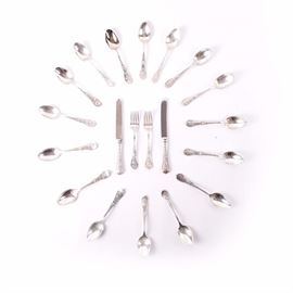Gorham Zodiac Sterling Silver Flatware: A collection of sterling silver zodiac flatware by Gorham. The set includes sixteen spoons, two youth knives and two youth forks. Each piece is decorated with a zodiac sign to the handle and marked “Sterling” to the backside. Some pieces feature engraved monograms and initials to the handles. The total approximate weight of all pieces is 19.900 ozt excluding the knives with stainless blades.