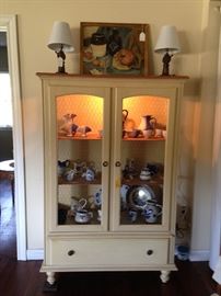 Buttermilk yellow lighted display cabinet with chickenwire insets. 
