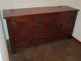 Mission Collection
Syracuse Sideboard
Derived from the sideboard that once graced Gustav Stickley’s home in Syracuse, New York, this impressive Mission sideboard includes two cupboard doors fitted with two adjustable shelves behind each. Four small drawers and three graduated drawers line the center of the piece with a Pacific Silvercloth® liner located in the third drawer down from the top. 
