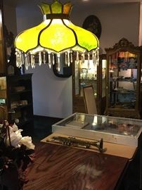 Hanging green slag glass chandelier with prisms, Besson trumpet, and curios filled with special items!