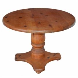 Round Pine Table with Turned Pedestal: A vintage round pine accent table with a turned spool style pedestal. The table is presented in a natural wood grain finish with rounded edges, a turned pedestal and sturdy base. No markings are included. Rug not included.