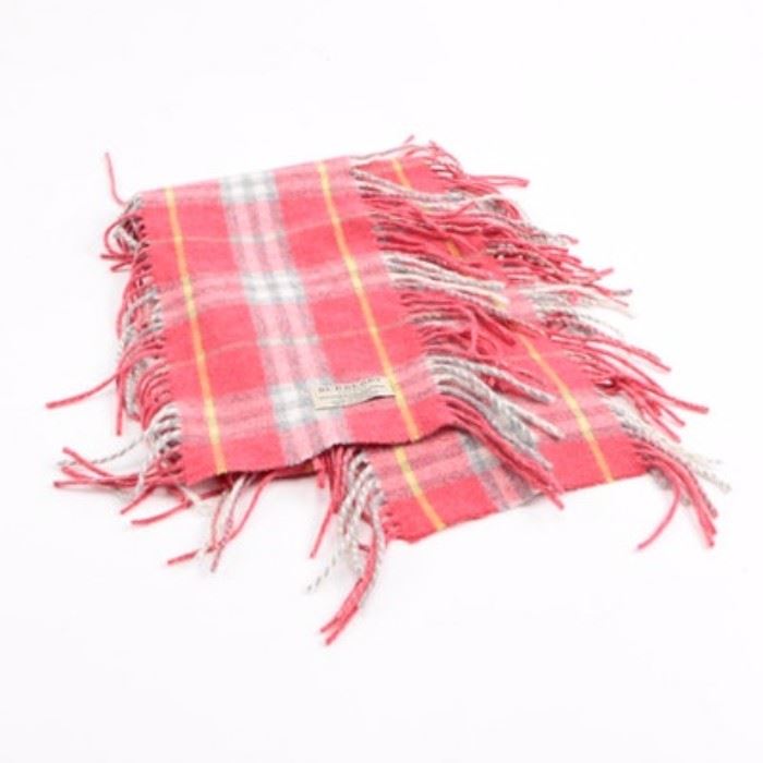 Burberry Wool Blend Scarf: A wool blend scarf by Burberry. This scarf showcases a plaid motif and a fringe presented in shades of pink, yellow, gray and white. It is marked with a brand label. Made in Scotland.