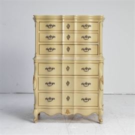 French Provincial Styled Chest of Drawers: A French Provincial styled chest of drawers..The chest features a total of six drawers in a chest on chest formation. The top set of drawers measure between 4" and 5" deep and the bottom drawers measure between 5" and 6" deep. Two of the bottom drawers feature dividers and the drawers are fitted with brass tone hardware and faux escutcheons. The chest is finished in a cream color with grooved line details painted in dark gold and stands on cabriole legs. Companion horizontal chest listed under 17LEX185-102