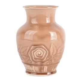 1945 Rookwood Pottery Vase With Rose Brown Glaze: A 1945 Rookwood vase with rose brown glaze. The vase features a high gloss glaze with a floral and leaf embossed border. Dated XLV (1945), the verso is marked with pattern No. 6767 and features the Rookwood flame hallmark. The piece is marked with an X denoting a factory second.