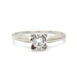18K White Gold Diamond Ring: An 18K white gold 0.34 ctw diamond ring. This ring features a center diamond with a small diamond at each corner. One corner is missing a small diamond.
