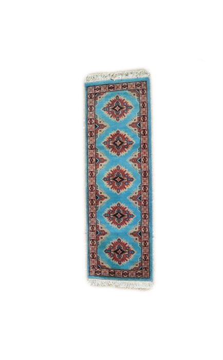 Hand-Knotted Pakistani Bokhara Carpet Runner: A hand-knotted Pakistan Bokhara carpet runner. This wool rug is rendered in a palette of cerulean, mauve, black, and taupe. It features an infinity pattern beginning with five starburst medallions arranged vertically over a cerulean field. Each medallion encloses a gul with out-pointing arrows amid abstract motifs. Framing the field are two borders, including an unresolved major border featuring alternating boxed florets and geometric Shirvan-style bracket motifs. Selvedges are overcast, the rug finishing at either end with ivory cotton fringe. It is unlabeled.