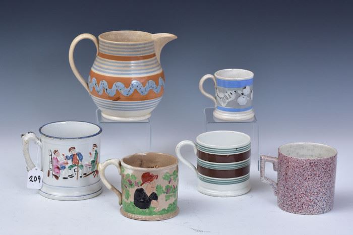 Group of Staffordshire
including Mochaware pitcher with
earthworm pattern, 6 3/8" high.
two Mochaware mugs, the largest 4" high
and three Staffordshire frog mugs,
the largest 4 3/4" high