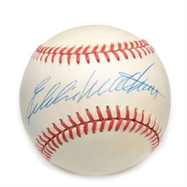 Eddie Mathews Signed Rawlings NL Baseball COA: A (HOF) Eddie Mathews signed Rawlings American League (White Pres.) baseball. Eddie signed this baseball on the “sweet spot” area in blue ink pen. The autograph is bold and smudge free and has been professionally authenticated by SGC with hologram affixed to the baseball. Please note, there is an accompanying SGC certification card enclosed. A member of the National Baseball Hall Of Fame, Eddie is a twelve- time All-Star. Elected to the Hall Of Fame in 1978, he passed away in 2001. The signed baseball is housed in a round protective holder without the base.