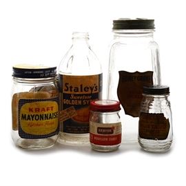 Six Vintage Kitchen Product Containers: An assortment of six empty vintage jars/can of everyday products. The jars are: “Honey Grove Sweet Pickles”; “Drum Pure Preferred Mustard”, the lid has manufactured holes; “Armour Bouillon Cubes”; “Kraft Mayonnaise Kitchen Fresh”; and “Staley’s Sweetose Golden Syrup” (missing the lid); The can is an “MacLaren’s Imperial Cheddar Club Cheese Sharp made by Kraft”.
