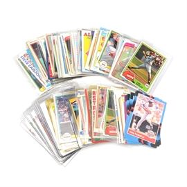1980s Baseball Card Collection With Hall Of Fame and Star Players: A collection of 1980s and 1990s baseball cards. This assortment includes players such as (HOF) Steve Carlton, (HOF) Robin Yount, (HOF) Gaylord Perry. (HOF) Tony Perez, (HOF) Fergie Jenkins, (HOF) Jim Palmer, (HOF) Tom Seaver, (HOF) Kirby Puckett, Pete Rose, Ken Griffey, (HOF) Rickey Henderson, Howard Johnson rookie, Eric Davis rookie, Darryl Strawberry, Nolan Ryan, (HOF) Tony Gwynn, (HOF) Reggie Jackson, (HOF) Dave Winfield, (HOF) Mickey Mantle “The Franchise,” (HOF) Ken Griffey “Promotional,” and others. Each card is housed in a protective sleeve or top loader.