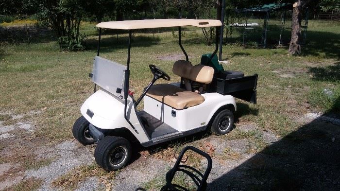 EZ-go golf cart with storage bed on back.