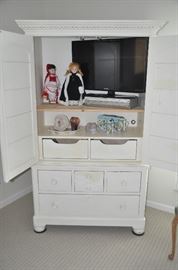 Shown open with a Samsung 32" flat screen tv and a Panasonic Double Feature VCR/DVD player and adorable decor