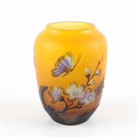 Reproduction Gallé Art Glass Vase: A reproduction Gallé art glass vase with a floral design. This piece features a yellow ground and low-relief butterflies and flowers in an assortment of colors. The piece is marked “Gallé” and “TIP,” indicating that it is a reproduction, along the side.