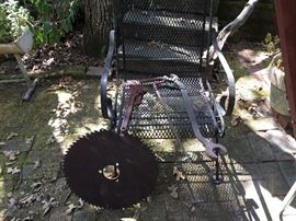 Old saw blade and another wrought iron chair