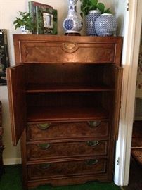 The burled wood clothing/storage armoire provides shelf and drawer space.