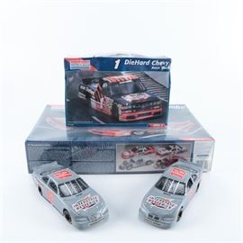 Monogram 1:24 Racing Model Car Kits and Action 1:24 Die Cast Cars: A pair of Monogram racing model car kits and Action 1:24 die-cast cars. 
The Monogram kits contain a #1 DieHard Chevy race truck and two ’87 Thunderbirds. The Chevy box is marked “Skill 2” and the Thunderbirds “Skill 3”. Both boxes are also marked “1:24 Scale”. The two matching light blue 1:24 scale die-cast Pontiac Gran Prix items are marked to the chassis “Action Performance Companies, Inc.”, models 0019 and 0021. The cars are marked on the bodies “Interstate Batteries – 18” and have hoods and trunks that open to reveal detailed interiors.