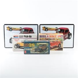 Vintage Roadster Model Car Kits: A grouping of vintage roadster model car kits. This grouping offers five kits including two Drag Team Double Dragster kits, a 1929 Ford Roadster Pick-Up, a 1929 Ford Model “A” Pick-Up by Monogram, and a 1928 Model “A” Ford by AMT. All kits are presented in original boxes in a 1/24 or a 1/25 scale.