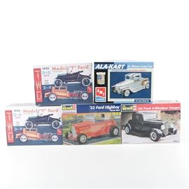 Collection of Model Car Kits featuring AMT: A collection of model car kits. This collection offers five kits including a 1932 Ford Highboy Street Rod, and a 1932 Ford 3-Window Coupe both by Revell. There are also three by AMT including two 1925 Model “T” Fords three in one kits, and an Ala-Kart custom built car by George Barris. All kits are presented in original boxes in a 1/25 scale.