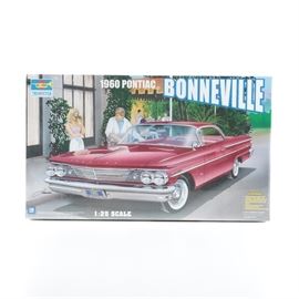 Trumpeter 1960 Pontiac Bonneville Model Kit: A Trumpeter 1960 Pontiac Bonneville model kit. This 1:25 scale model features a detailed interior and an opening hood and trunk. It is sealed in its original packaging.