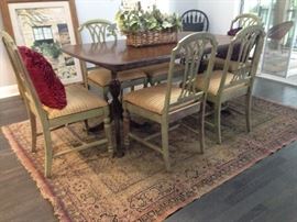 Staging furniture including wood table and chairs. Distressed antique rug.