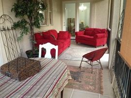 Sofa and armchair set with wicker chair and wood chairs. Plastic tree. Staging furniture.