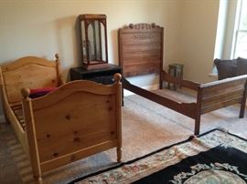 Two wood bed frames with side tables and mirrored showcase. 