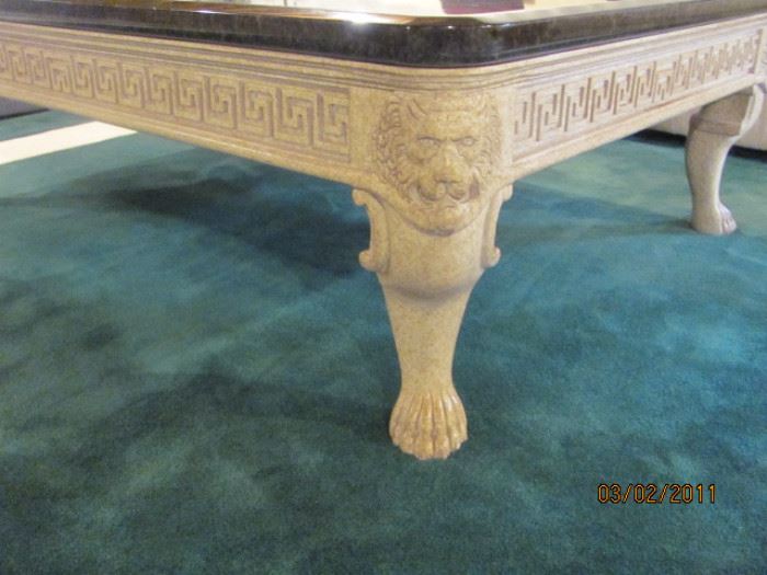 Brown marble like 45"x5' coffee table with ivory tone carved lions heads and paws
