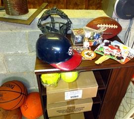 Old catcher's mask, boxes of new softballs, basketballs