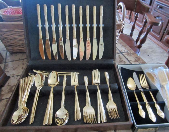 One of two gold tone stainless flatware sets and a Oneida service for four set.    Service for eight, with serving pieces, and extra t-spoons (appear never used).