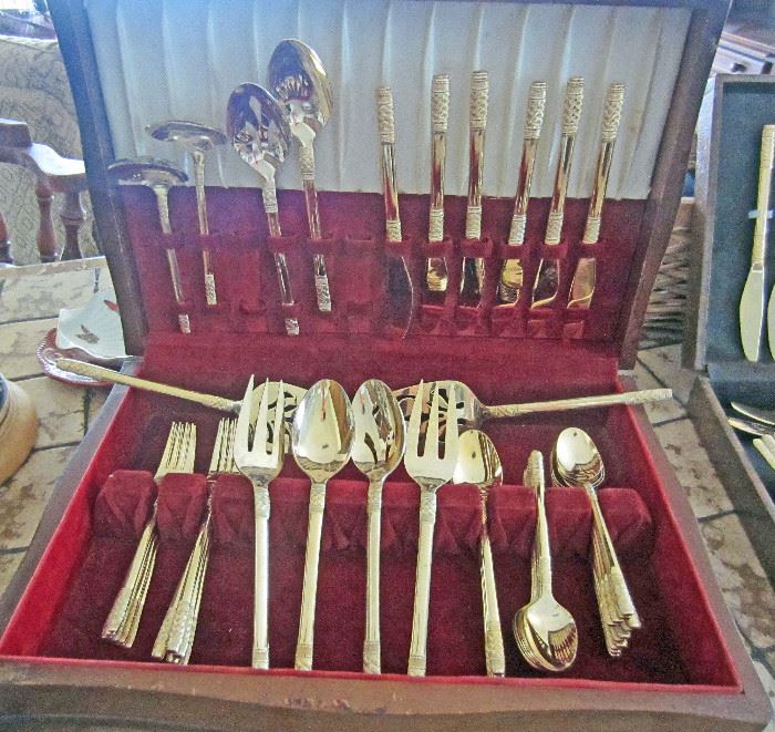 One of two gold tone stainless flatware sets.  Service for eight, with serving pieces, and extra t-spoons (appear never used).