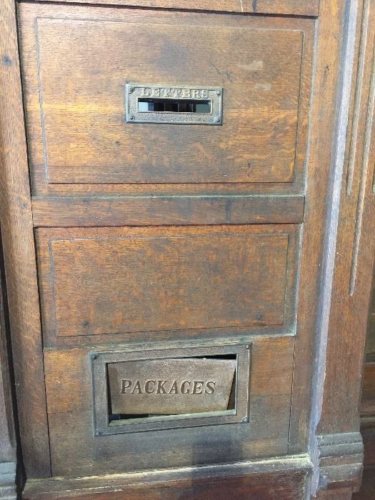 Brass mail slots on antique post office doors. 