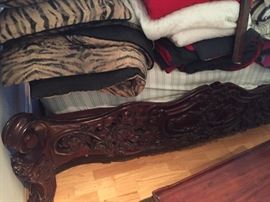 Linens and ornate wooden bed.