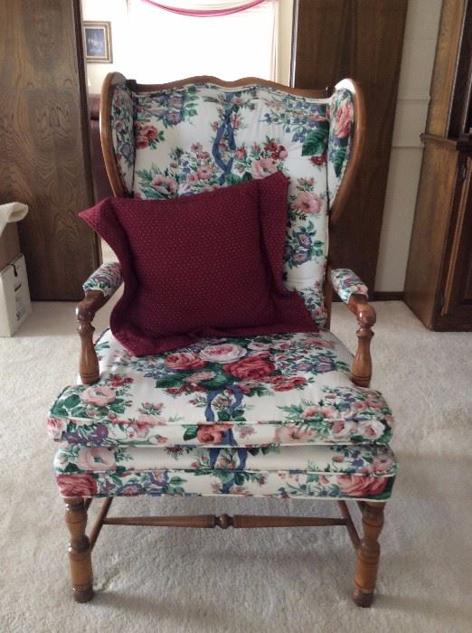 There are two floral wingback chairs.
