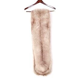 Fox Fur Stole: A fox fur stole. This stole features white pelts with brown accents and is lined with a grey satin style lining. The stole features two interior pockets accented with a bow and no maker’s label.