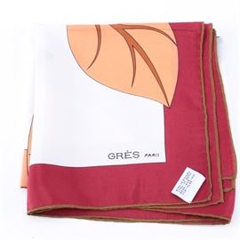 Vintage Grès Silk Scarf: A vintage Grès silk scarf. This 100% silk scarf features a large floral pattern in blue, brown and white against a white field with “Grès Paris” printed to the lower right corner. The scarf has a magenta border with brown hand-rolled edges. A fabric tag is attached to bottom corner that states “100% Silk Made In Italy”.