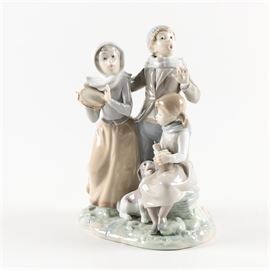 Lladro Figurine of Three Children Playing Music: A Lladro figurine of three children playing music. This porcelain figurine depicts a nostalgic scene of three children singing together while a small dog begs at the lap of the youngest child. This piece is marked on the base “Lladro Hand Made in Spain”.