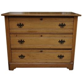 Antique Chest of Drawers: An antique chest of drawers. This low piece has an overhanding top, over three stacked drawers, set in a simple case with incised lines on the front stiles and paneled sides, with corner bracket feet and an applied apron. The Knapp jointed drawers have horizontal lines incised across their faces, bordering brass bails on batwing plates. The back has horizontally set, unfinished boards.