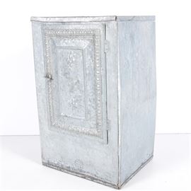 Tin Pie Safe or Bread Box: A tin pie safe or bread box. This tin metal rectangular pie safe features a hinged door with raised gadroon border and fleur di lis accent and metal latch that opens to reveal three interior shelves. Cabinet has a pierced star pattern to the back and has a slat wood supported base.