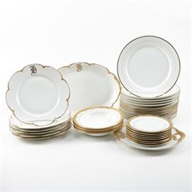 Collection of Gilt Trimmed Tableware: A collection of tableware with gilt trim. This collection features thirty-five pieces of porcelain tableware including serving platters, dinner plates, salad plates, salad bowls, and saucers. The items are presented in white with gilt trim with markings such as “Theodore Haviland Limoges France”, “Ovington Brothers Mintons Made in England”, “C. Ahrenfelot Limoges L. B. King & Co.”, and “Pope-Sosser China Made in U.S.A. I-27”.