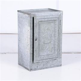 Metal Pie Safe: A metal pie safe. This rectangular metal cabinet features a hinged door with raised gadroon border and crest accent that opens to two shelves with perforated circular shape to the back. Cabinet sits flush to the floor.