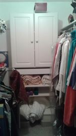 Closet full of comforters, clothing , shoes and shelving.  The Shelves are not attached, they are California Closet and can be picked up on the spot