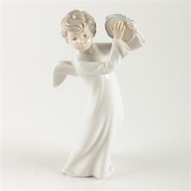 NAO "Angel With Tambourine" Figurine: A NAO Angel With Tambourine figurine. This NAO porcelain figurine sculpted by Francisco Catalá, issued in 1992, depicts an angel playing a tambourine. The figurine is marked “NAO hand made in Spain by Lladró” to the underside and is number 0189 in the NAO catalog.