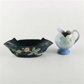 Pair of Ceramic Decor: A pair of ceramic decor. Featured is a Roseville vessel with a floral motif that has been painted black . The bottom of vessel is marked “Roseville, 756-12 1/2”. Also included is a Weller vessel with a yellow flowers against a pale blue background. This piece is marked Weller to the underside.