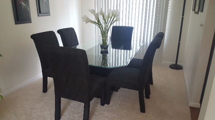 Rectangle beveled glass dining table with six black fabric rolled back parsons chairs.  Perfect condition.