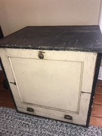 Super fun wooden vintage storage cabinet side accent table with front drop down door and shelving inside. Located in the house.