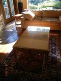 Lovely sleek coffee table with a glass top 49"l x 29 1/2"w x 18"h. $220.00 Coffee table matches end table and armoire in following pictures. Sofa not for sale