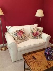 Lovely small white sofa with needlepoint pillows!
