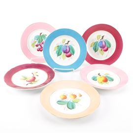 Porcelain Fruit Motif Plates Including Limoges: A selection of six porcelain plates. Each plate features a central colorful fruit motif design with various colored borders including red, blue, and pink. Each plate is trimmed in gilt. Some pieces are marked to the underside “D&C”.