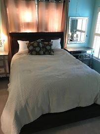 full sized bed with bedding and headboard